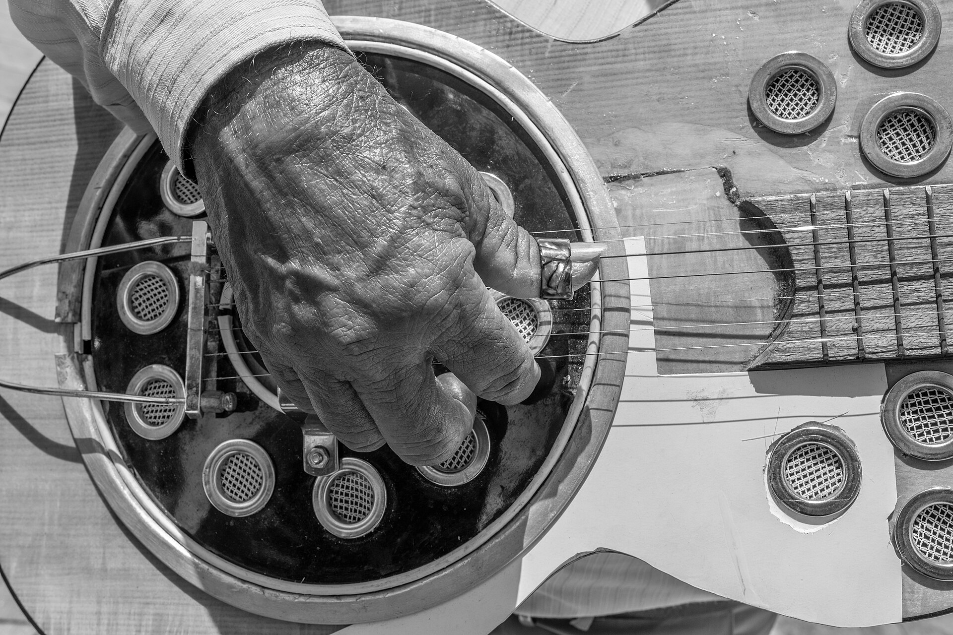 Close up of hands fretting and strumming an acoustic guitar