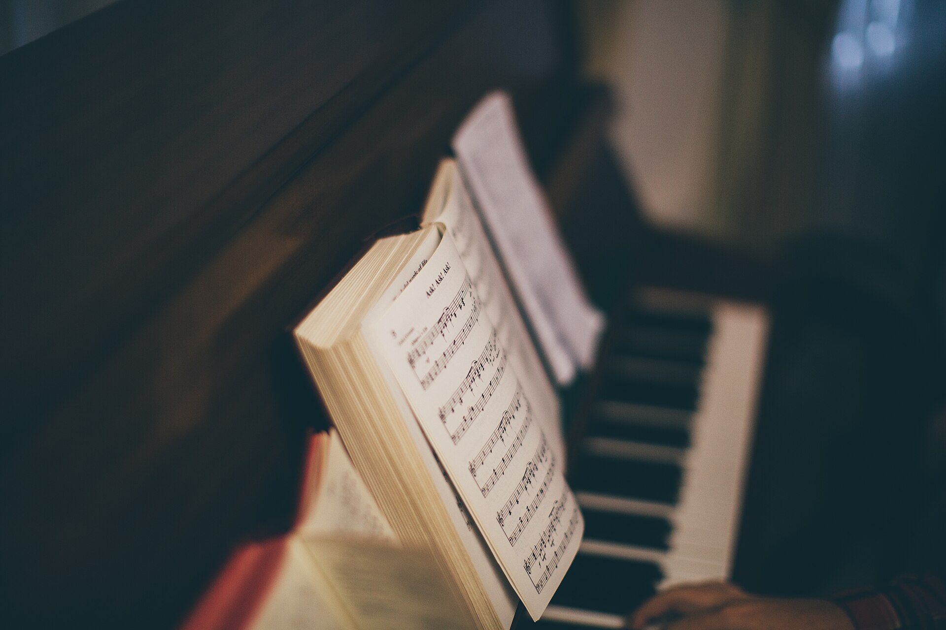 Pianist hands on a keyboard with an open music score