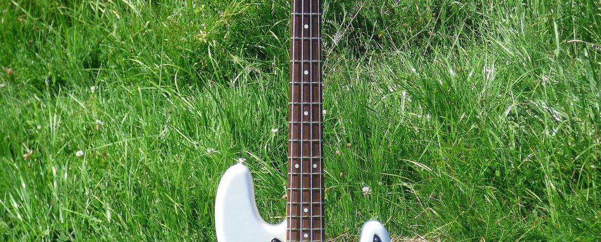 Fender Precision Bass standing in the grass, shown as a classic bass guitar for beginners in Australia