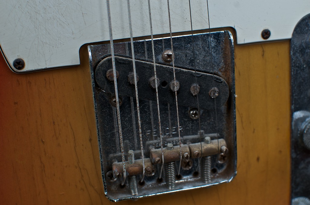 Close up of a Fender Telecaster bridge pickup and metal bridge plate