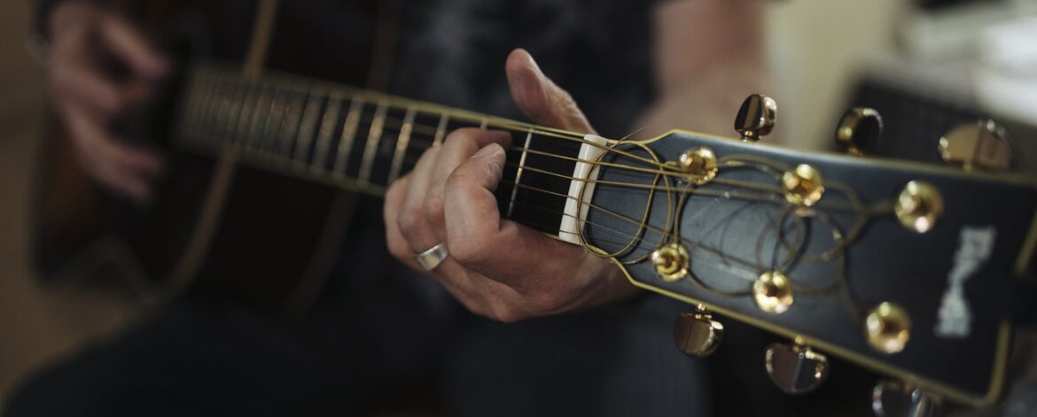 guitar_injuries_hands_on_acoustic_guitar Guitar injuries prevention starts with relaxed hands on an acoustic guitar neck and strings