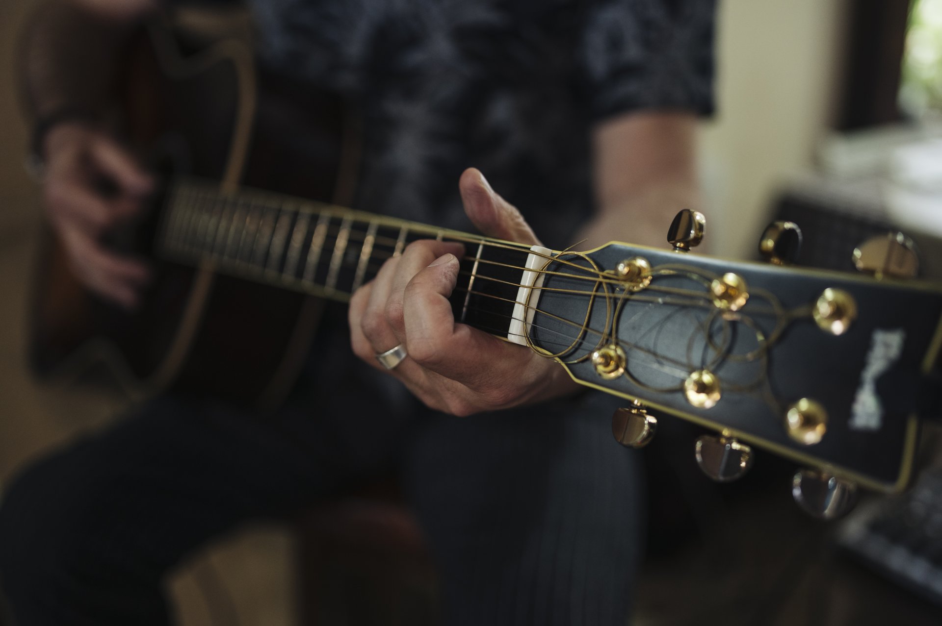 Guitar injuries prevention starts with relaxed hands on an acoustic guitar neck and strings