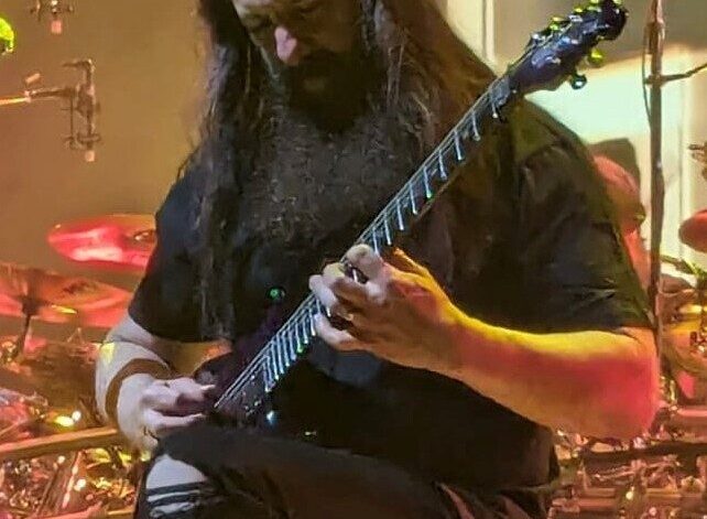 John Petrucci playing live in Milan in 2024; his guitar practice routine splits time into short blocks